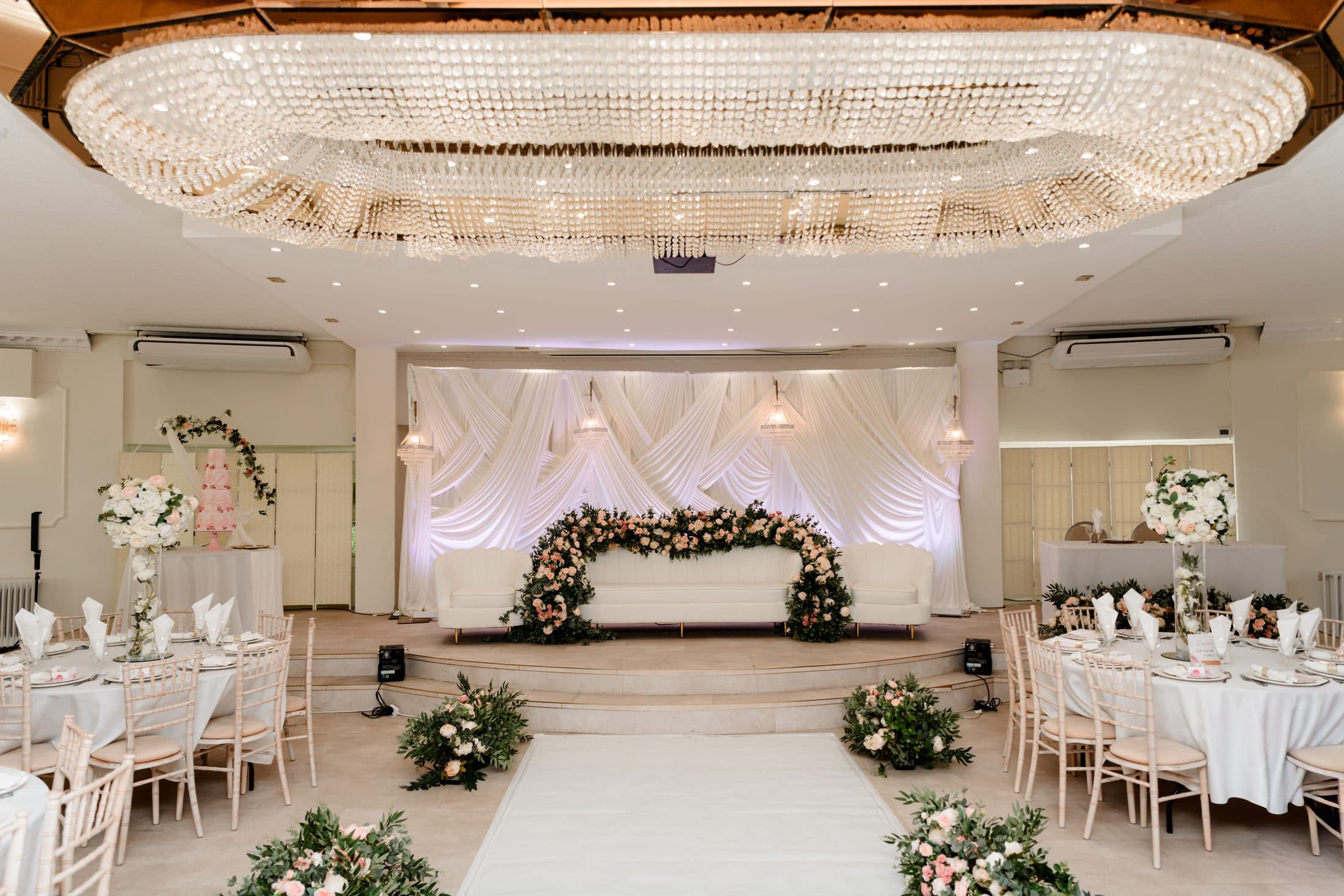 The Crystal Room under its chandelier, dressed in white